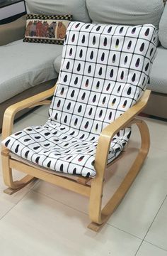 a wooden rocking chair sitting on top of a hard wood floor next to a couch