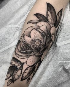 a black and white flower tattoo on the arm