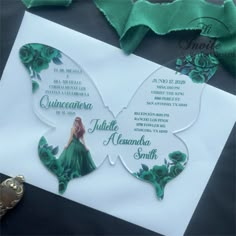 a butterfly shaped wedding card on top of a white piece of paper with green ribbon