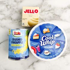 two cans of jello and a can of pineapple on a marble counter top