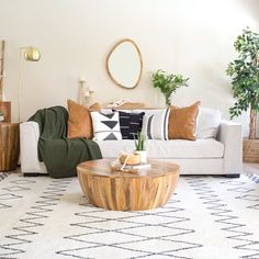 a living room filled with lots of furniture and pillows on top of a white rug