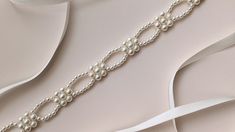 I designed this exquisite Floral Bridal Belt to add dainty elegance and sophistication to your wedding attire. This beautiful beaded sash for wedding dresses features a delicate floral design embellished with lustrous pearls in a subtle tone that evokes a vintage style. The pearl embellishment measures approximately 10.6 inches, providing the perfect accent to your bridal look. With plenty of ribbons, this Floral Bridal Belt ensures a customizable fit, making it ideal for any bride seeking to en Metal Hair Accessories, For Wedding Dresses, Pearl Statement Necklace, Back Necklace, Bride Accessories, Pearl Cream, Bridal Belt, Hypoallergenic Jewelry, Bridal Bracelet