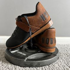 two brown and black shoes sitting on top of each other