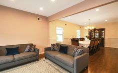 a living room with two couches and a dining table in the backround