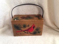 a wooden box with a red bird painted on it