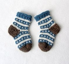 two blue and white knitted mittens laying on top of each other