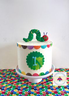 a very cute looking cake with a number one on it's side and a caterpillar on the top