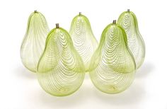 four green glass pears sitting next to each other