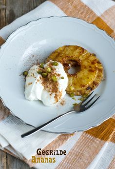 a white plate topped with fruit and whipped cream