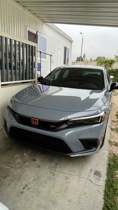 a gray car parked in front of a building