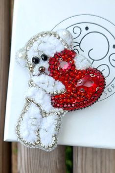 a white teddy bear holding a red heart