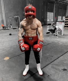 a man wearing boxing gloves standing in a gym