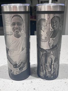 two travel mugs with pictures of black men on them sitting on a counter top