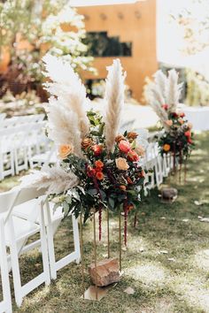 an outdoor ceremony with white chairs and flowers