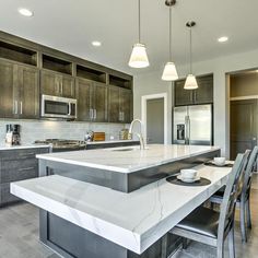 a large kitchen with marble counter tops and stainless steel appliances