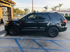 a black suv parked in front of a gas station with blue lines on the ground