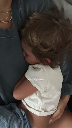 a small child laying on top of a woman's lap