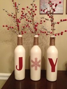 three wine bottles decorated with red berries and snowflakes are sitting on a table