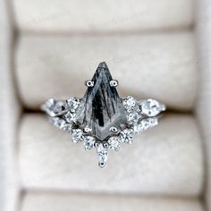 a diamond ring sitting on top of a white cushion