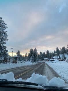 the road is covered in snow and trees