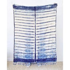 a blue and white tie - dyed blanket hanging on the wall in front of a door