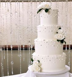 a wedding cake with white flowers and pearls