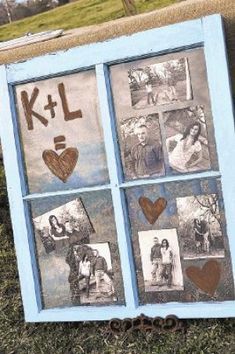 an old window decorated with pictures and hearts is displayed on the grass in front of a sign