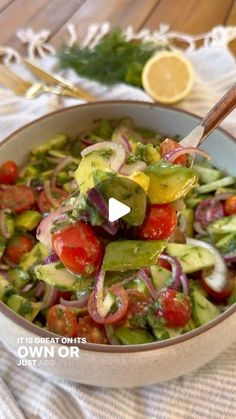 a salad with tomatoes, cucumbers and onions in a bowl on a table