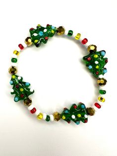 Rock around the Christmas tree with this glass beaded stretch bracelet. Glass seed beads add onto the bright colors of the tree making it the merriest accessory this holiday season!  Bracelets are available in a variety of lengths.  Pick your custom length from the drop down menu below.  Please be aware that beading may slightly differ from what is pictured as to accommodate selected sizing.  All our bracelets are made with quality in mind.  With that being said, all bracelets should be treated Christmas Beaded Stretch Bracelet Gift, Christmas Holiday Beaded Bracelets With Colorful Beads, Multicolor Beaded Bracelets For Christmas Holiday, Festive Green Beaded Bracelets With Colorful Beads, Adjustable Beaded Stretch Bracelet For Christmas, Festive Green Beaded Bracelets, Colorful Beads Bracelets For Christmas Holiday, Colorful Beaded Bracelets For Christmas Holiday, Colorful Beads Bracelets For Christmas