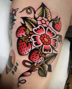 a woman's thigh with flowers and strawberries on it