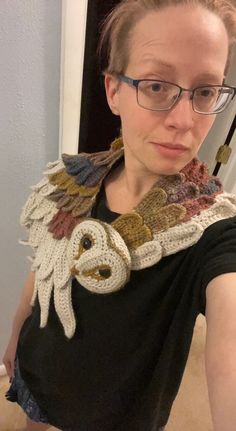 a woman taking a selfie in front of a mirror with an owl scarf around her neck