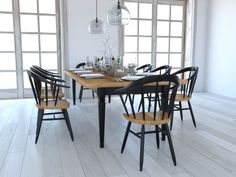 a dining room table and chairs in front of large windows