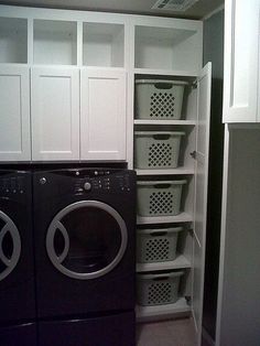 an appliance is displayed in the corner of a room with white cabinets and black washer and dryer