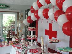 a red cross themed party with balloons and desserts