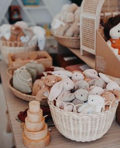 baskets filled with stuffed animals sitting on top of a wooden table next to other items