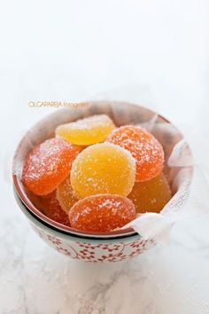 a bowl filled with gummy bears sitting on top of a white tablecloth covered floor