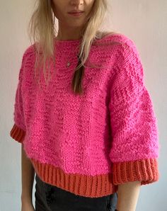 a woman with blonde hair wearing a pink sweater