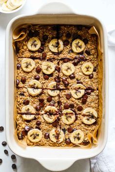 baked oatmeal with banana slices and raisins in a white casserole dish