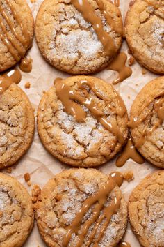 cookies covered in chocolate drizzled with icing on parchment paper, ready to be eaten