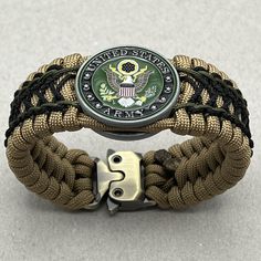 an army bracelet with a us seal on the front and two braided bands around it