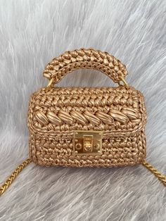 a straw bag with gold handles on a white furnishce background and a golden chain