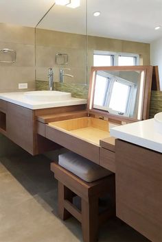 a bathroom with a large mirror, sink and stools in it's center