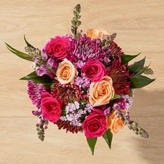 a bouquet of flowers sitting on top of a wooden table