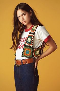 a young woman is posing for the camera wearing a t - shirt with crochet on it