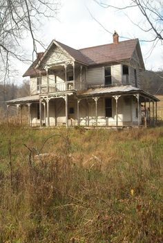 an old run down house sitting in the middle of a field