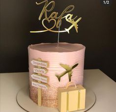 a pink cake with gold letters and an airplane on top