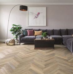 a living room filled with furniture and a large painting on the wall above it's corner