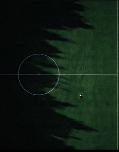 an overhead view of a soccer field with two players on it and one ball in the middle