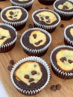 black bottom cupcakes with chocolate chips and cream filling in them on a wooden surface