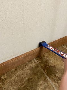 a person holding a toothbrush in front of a wall